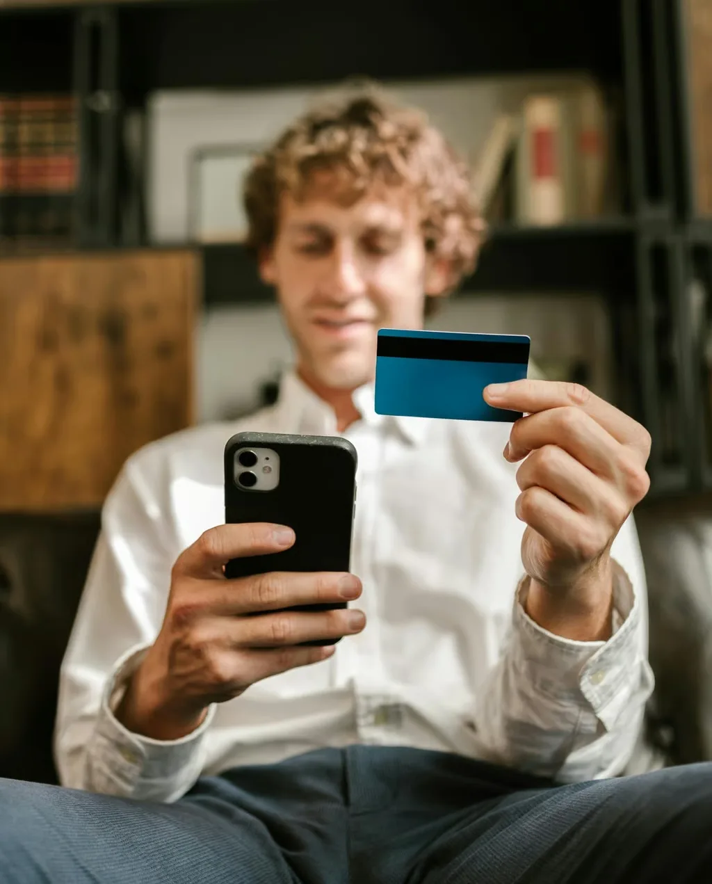 Person hält Karte und Smartphone in der Hand und prüft Kontooptionen.