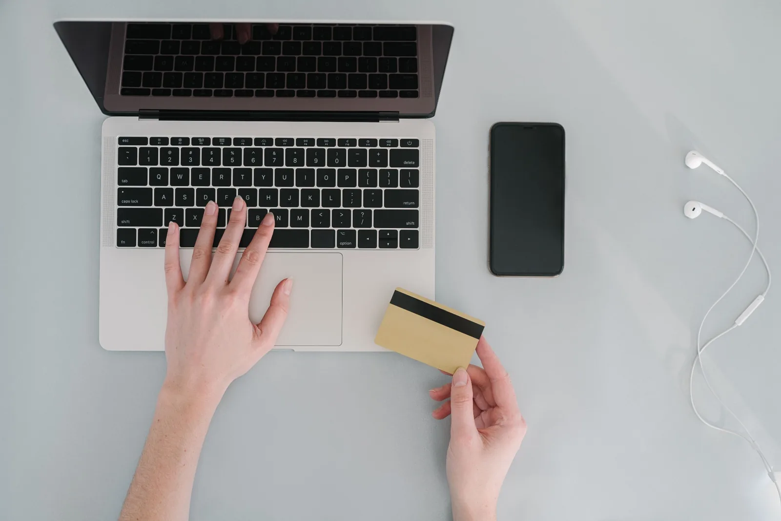 Draufsicht auf eine Person, die mit Laptop und Karte Konten vergleicht.